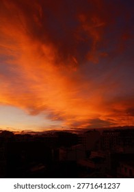Fiery sunset cloudburst over city skyline, film grain, Vertical