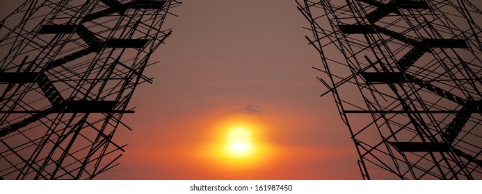 A fiery sunset showcase between a pair of scaffold tower.  - Powered by Shutterstock