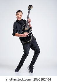 Fifteen Years Old Guitarist With A  Black Electric Guitar. Teenage Musician Holds Guitar, Posing At Studio. The Young Caucasian Guy With A Guitar. Boy's Playing Rock Music. Heavy Metal Player. 