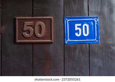 Fifty fifty deal, concept. Half for me , half for you. Numbers. 50. Wooden dark  backdoor background. Square shapes two metal boards, brown and blue colors.