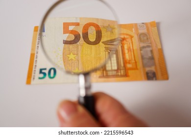 fifty euro banknote viewed with a magnifying glass