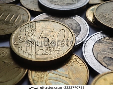 Fifty euro cents close up detail with many euro coins around it, money background, savings in financial crisis