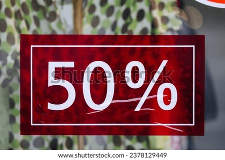 Fifty percent off sale sign in a shop window