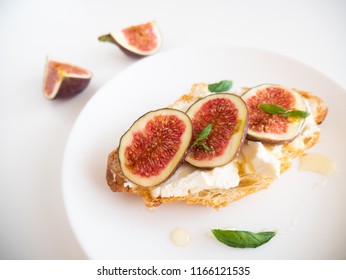 Fig And Cream Cheese Open Face Croissant Sandwich On A White Plate