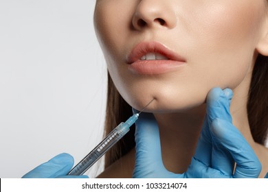 Fight against wrinkles. Close up of female chin. Young woman getting collagen injection. Isolated and copy space