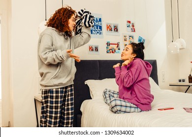 Fight For Sweater. Two Funny Young Roommates Having Fight For Nice Striped Sweater