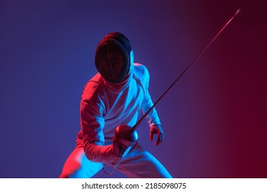 Fight in swordplay. Male fencer with smallsword practicing fencing isolated on purple background in neon light. Athlete practicing in motion, action. Copyspace for ad. - Powered by Shutterstock