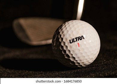 The Fight with virus. Allegory. Golf ball and golf club on black background. ( ULTRA word is not a brand, it is kind (type) of balls.)