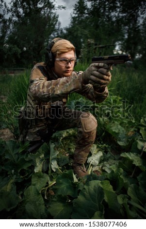 Fighter in full ammunition with a weapon at the time of game. A warrior runs and shoots on move