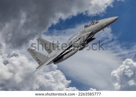 Fighter Jet in action. Fast Jet, armed  military aeroplane on a combat mission. F-15 Eagle at a dramatic angle flying at speed