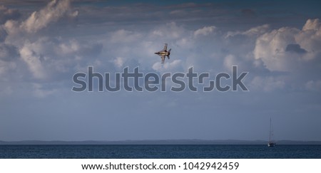 Fighter jet flying low and fast over water