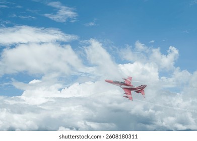 Fighter jet flying through cloudy blue sky on background with copy space