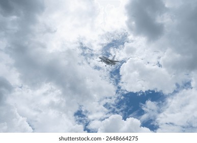 Fighter jet flying through cloudy blue sky on background with copy space