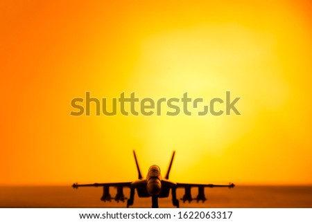 Fighter jet scale model (toy) in a sunset scenary.