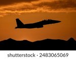 Fighter jet at sunset flying above mountains. Fighter pilot on a combat mission  in modern military aeroplane. 