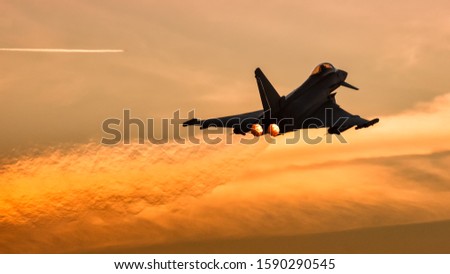 Fighter jet taking off at sunset