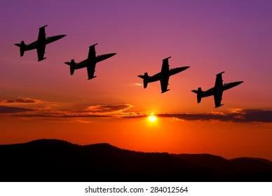 Fighter jets in the sky at sunset