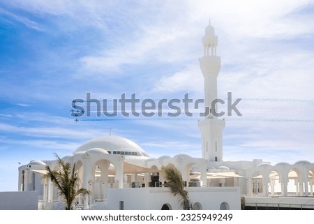 Fighter Jets Squadron with smoke traces over Alrahmah mosque, Jeddah, Saudi Arabia