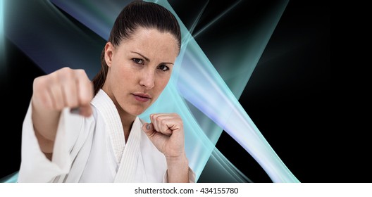 Fighter performing karate stance against black background - Powered by Shutterstock