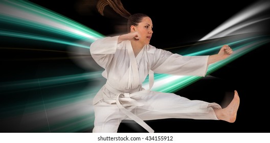 Fighter performing karate stance against black background - Powered by Shutterstock