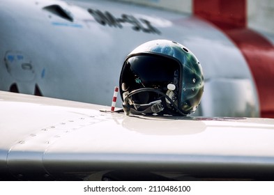 FIghter pilot helmet on wing of fighter jet.