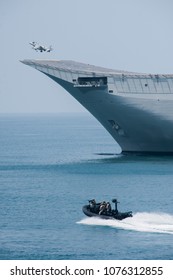 A fighter plane during a vertical take-off from an aircraft carrier at sea. A spanish navy combat plane during a war operation at sea