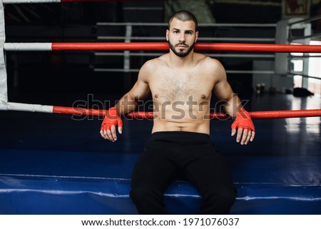 Fighter Practicing Some Kicks With Punching Bag. Kick, punching bag on dark background. Black punching bag weighs at the gym