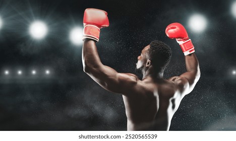 Fighter winner. African boxer raising his hands in boxing gloves, demonstrating victory to audience at stadium, free space - Powered by Shutterstock