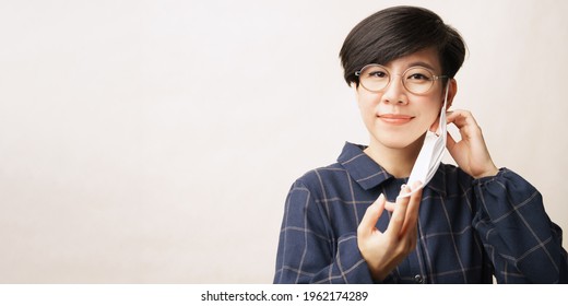 Fighting Against Covid 19 Concept. Banner Of A Beautiful And Healthy Asian Woman About To Take Off Or Putting On Her Face Mask. Stop Spreading Awareness, Recovery, Vaccinated, Herd Immunity, Pandemic.