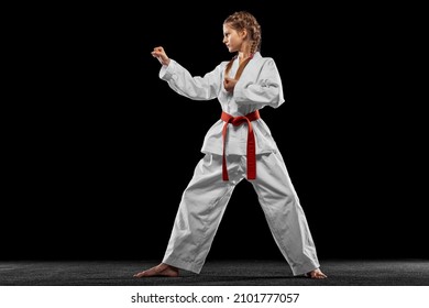 Fighting Stance. One Young Girl, Teen, Taekwondo Athlete Posing Isolated Over Dark Background. Concept Of Sport, Education, Skills, Workout, Healthy Lifestyle And Ad. Power And Energy.