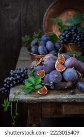 Figs, grapes and plums on an old wooden table. Still life in rustic retro style. - Shutterstock ID 2223015409