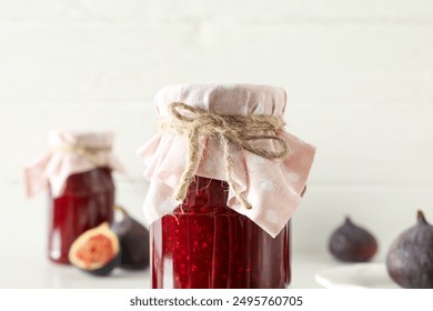 Figs and jars of jam on white background, close up - Powered by Shutterstock