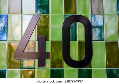 The Figure 40 Outside An Office Block In Central London.  Bronze Numbers Placed On Green Ceramic Tiles.