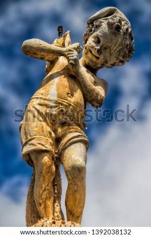 figure at the ancient fountain Fontana del Pescatorello in Prato, Italy
