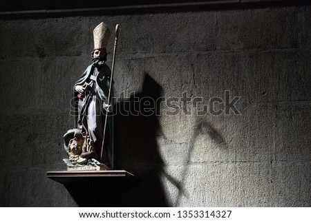 Figure of a bishop throwing a shadow of a grimreaper