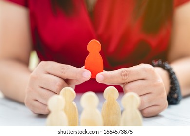 Figure in human resource management concept. The red wood figure was picked out of its group. Red Wood figure like who is selected from the candidate, or choose the most dominant in the team - Shutterstock ID 1664573875