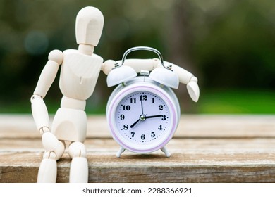 Figure of a man and an alarm clock. The concept of time, circadian rhythm, deadline. - Shutterstock ID 2288366921