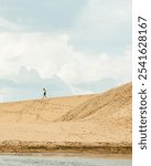 a figure on a ridge of a sand dune