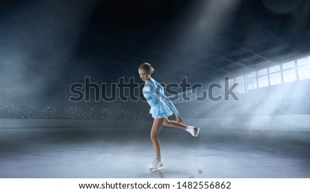 Figure skating girl in professional ice arena.