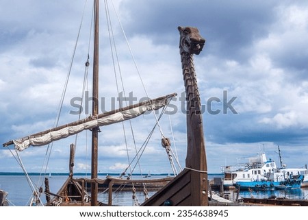 figurehead on the bow of a full-scale replica of a viking ship, moored in port