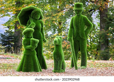 Figures of man, woman, child and dog created from bushes. Topiary gardens.
