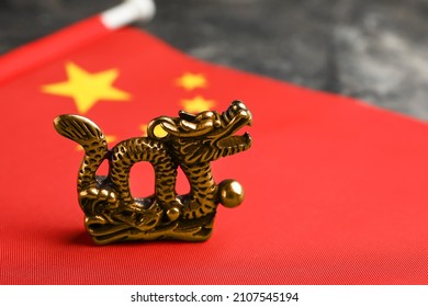 Figurine Of Dragon And Chinese Flag On Dark Background