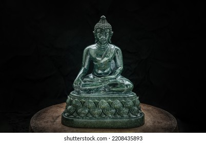 Figurine of Emerald lord buddha gautama or Siddhattha gotama buddha sculpture statue with dark background. Space for text, Selective focus.