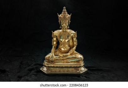 Figurine of Gold Brass Phra Phut Sik Khi Thotsaphon (First Buddha) buddha sculpture statue with dark background. Space for text, Selective focus.