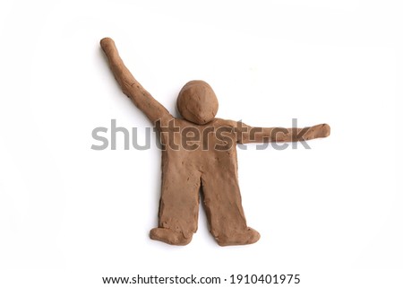 Figurine of natural clay  isolated on white background.  Doll man of wet clay material for sculpting or modeling.
