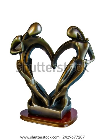 A figurine in the shape of a heart. Loving couple holding hands. Bronze sculpture on a white background.