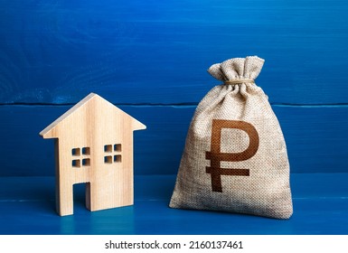 Figurine silhouette house and russian ruble money bag. Maintenance, property improvement. Mortgage loan. Sale of housing. Proposal for a deal price. First installment. Buying and selling real estate.