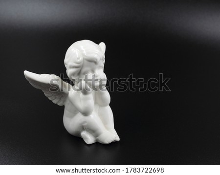 Figurine of a white angel on a black background