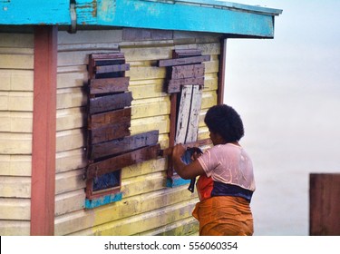 FIJI - DEC 17 2016:Fijian woman boarding up her house during a Tropical Cyclone. On Feb 2016 Severe Tropical Cyclone Winston was the strongest tropical cyclone in Fiji in recorded history.