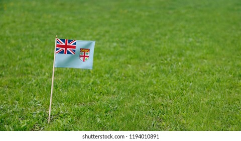 Fiji Flag. Photo of Fiji flag on a green grass lawn background. National flag waving outdoors. - Powered by Shutterstock